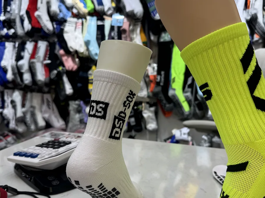 Showroom de DeporMia: calcetines antideslizantes sobre maniquí con el muestrario detrás (foto real)